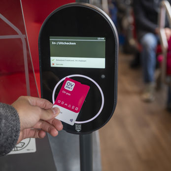 Reiziger checkt in met OV-pas in bus Reiziger checkt in met OV-pas in bus