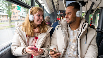 Man en vrouw luisteren samen muziek in HTM bus Man en vrouw luisteren samen muziek in HTM bus