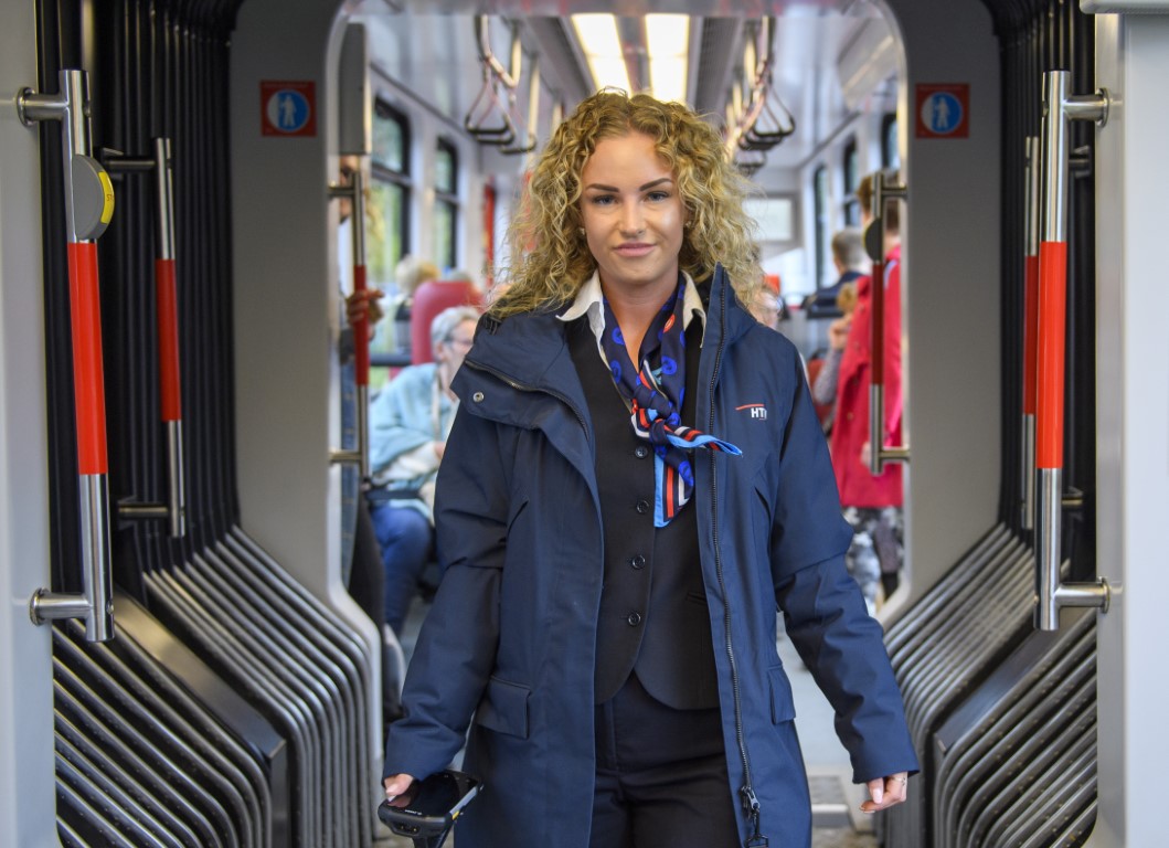 HTM BOA controleur staat in HTM tram en lacht naar de camera