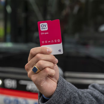 Mannenhand met OV-pas in zijn hand Mannenhand met OV-pas in zijn hand