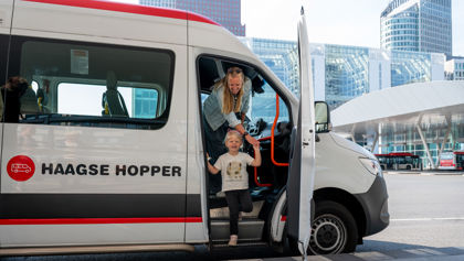 Een vrouw en klein kind stappen uit de Haagse Hopper op het busplatform Den Haag Centraal Foto van vrouw en kind die uit de Haagse Hopper stappen