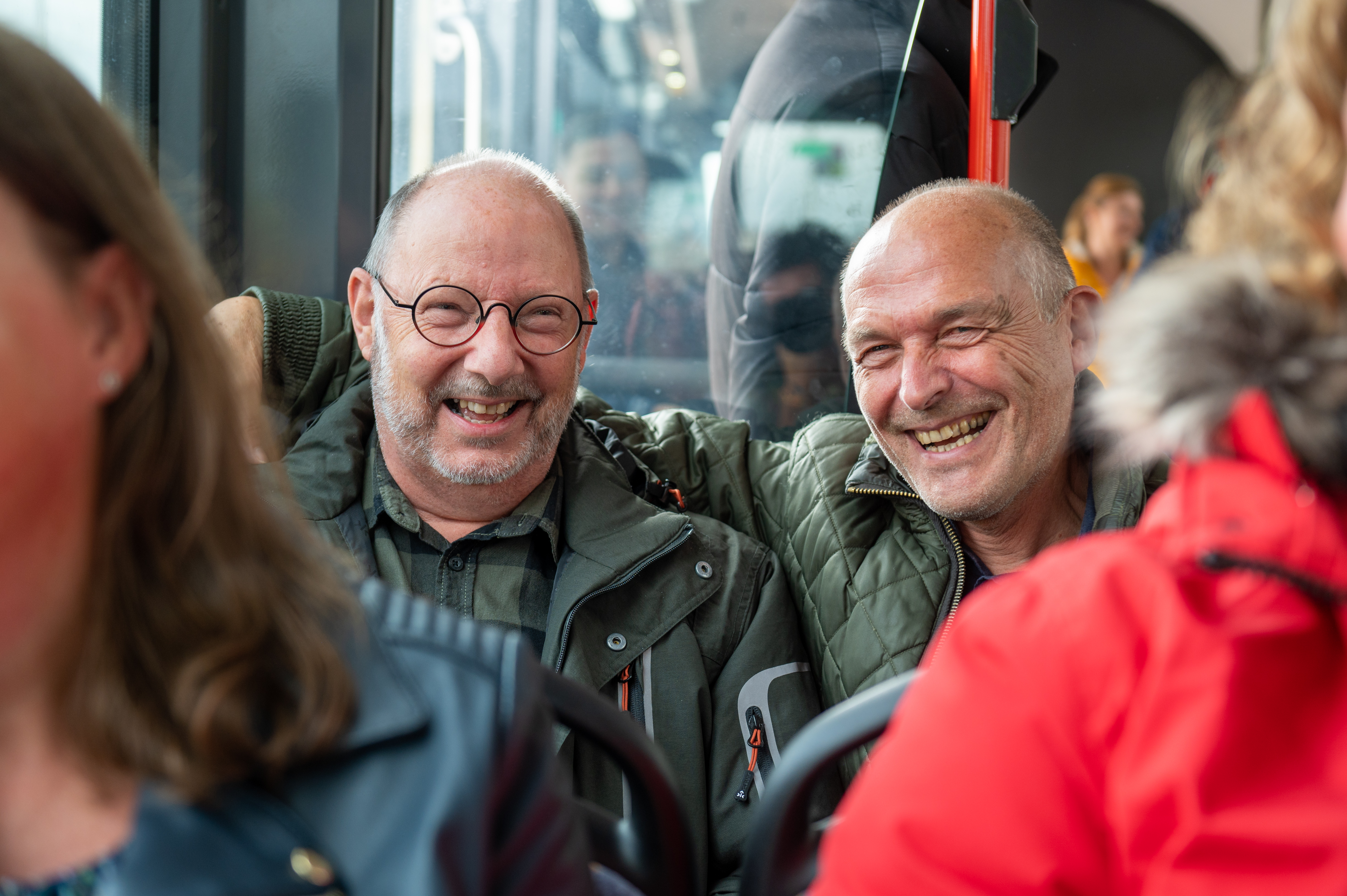 Reizigers zitten in HTM bus en lachen naar de camera