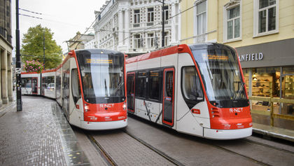 Twee trams rijden langs elkaar Twee HTM trams langs naast elkaar langs winkels in Den Haag