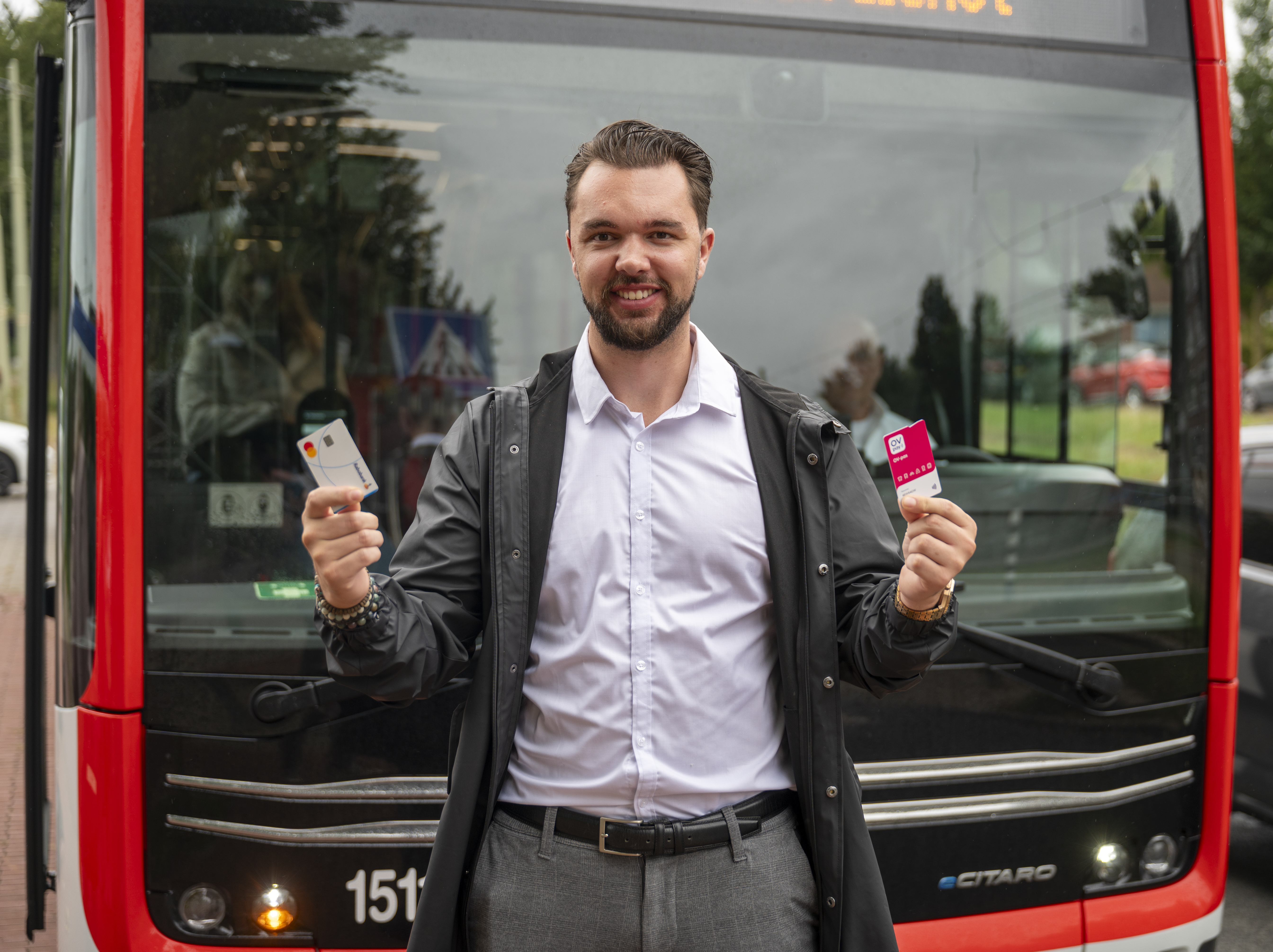 Man voor HTM bus met betaalpas en OV-pas in zijn handen (2)