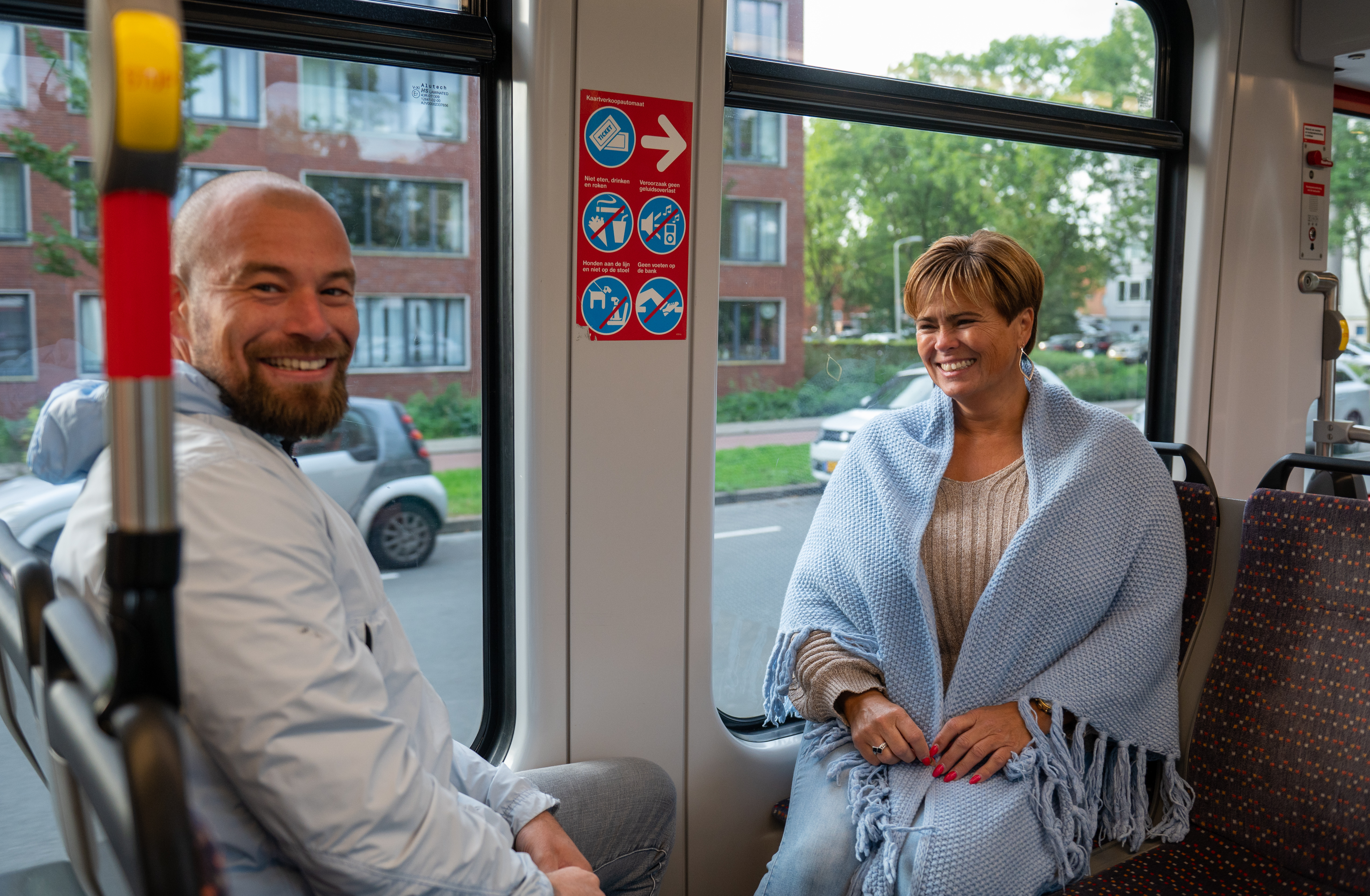 Reizigers zitten in HTM tram en kijken naar de camera