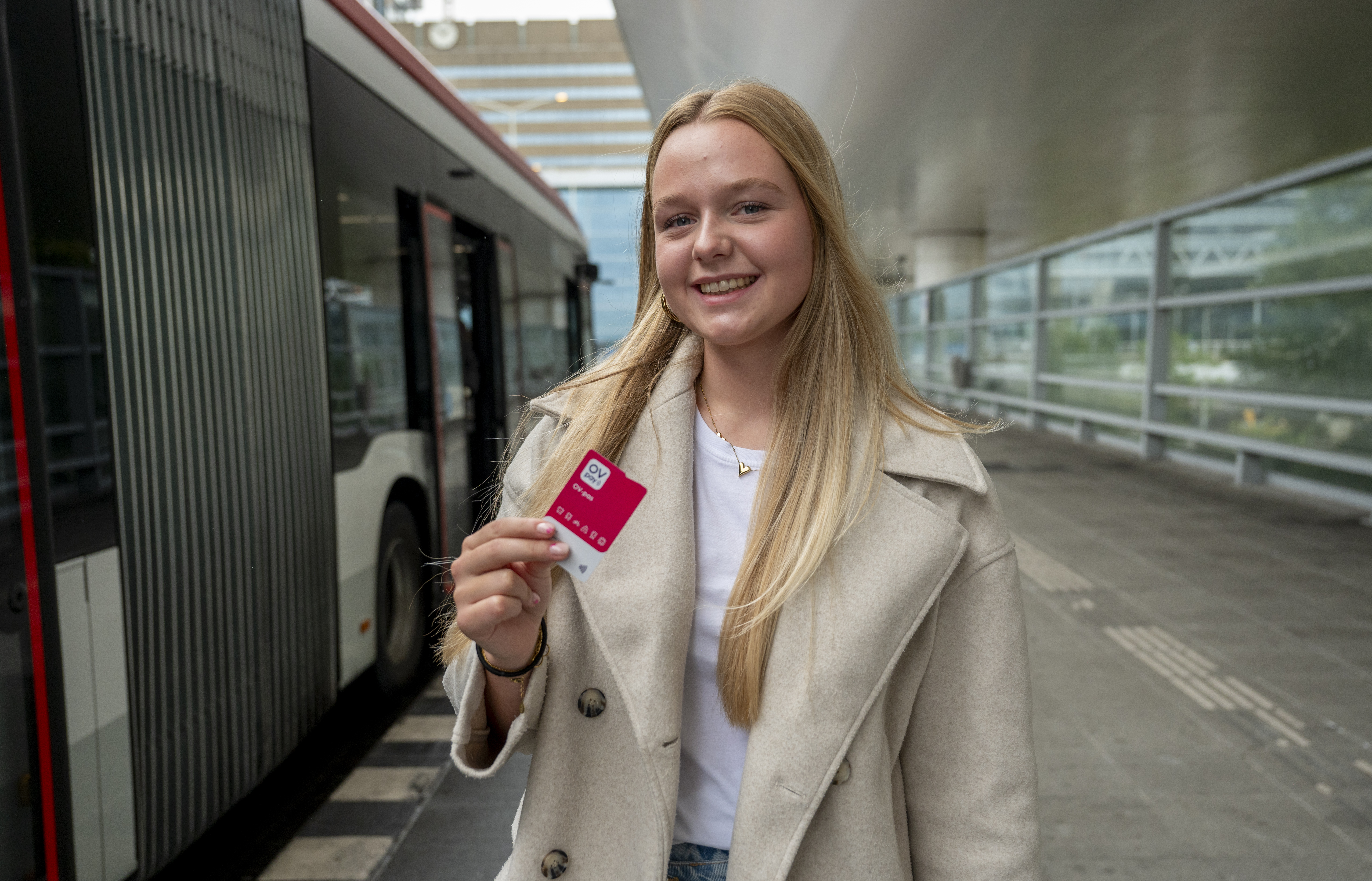 meisje op HTM bus perron met nieuwe OV-pas in haar handen
