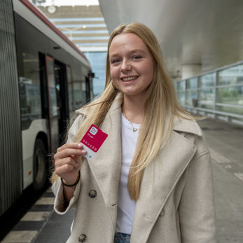 meisje op HTM bus perron met nieuwe OV-pas in haar handen meisje op HTM bus perron met nieuwe OV-pas in haar handen