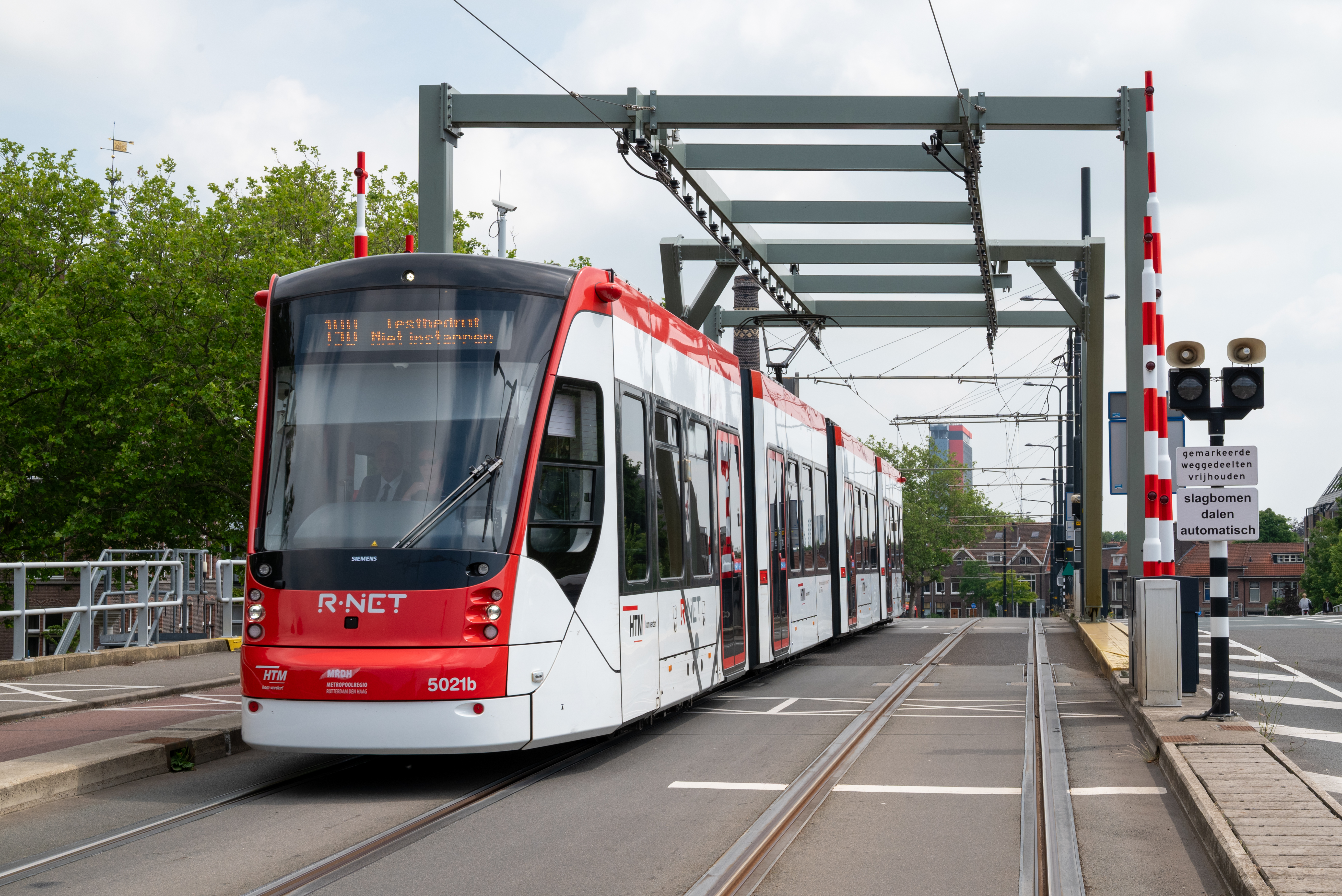 Een rood-witte Avenio tram op de Sebastiaansbrug in Delft