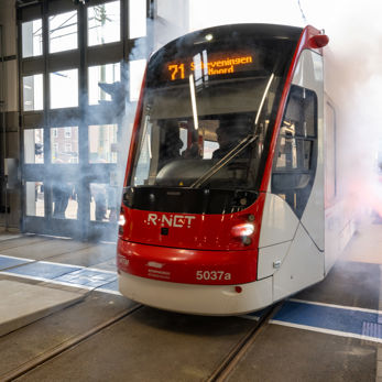 Een Avenio-tram van HTM rijdt door een rookgordijn de vernieuwde remise in Een Avenio-tram van HTM rijdt door een rookgordijn de vernieuwde remise in