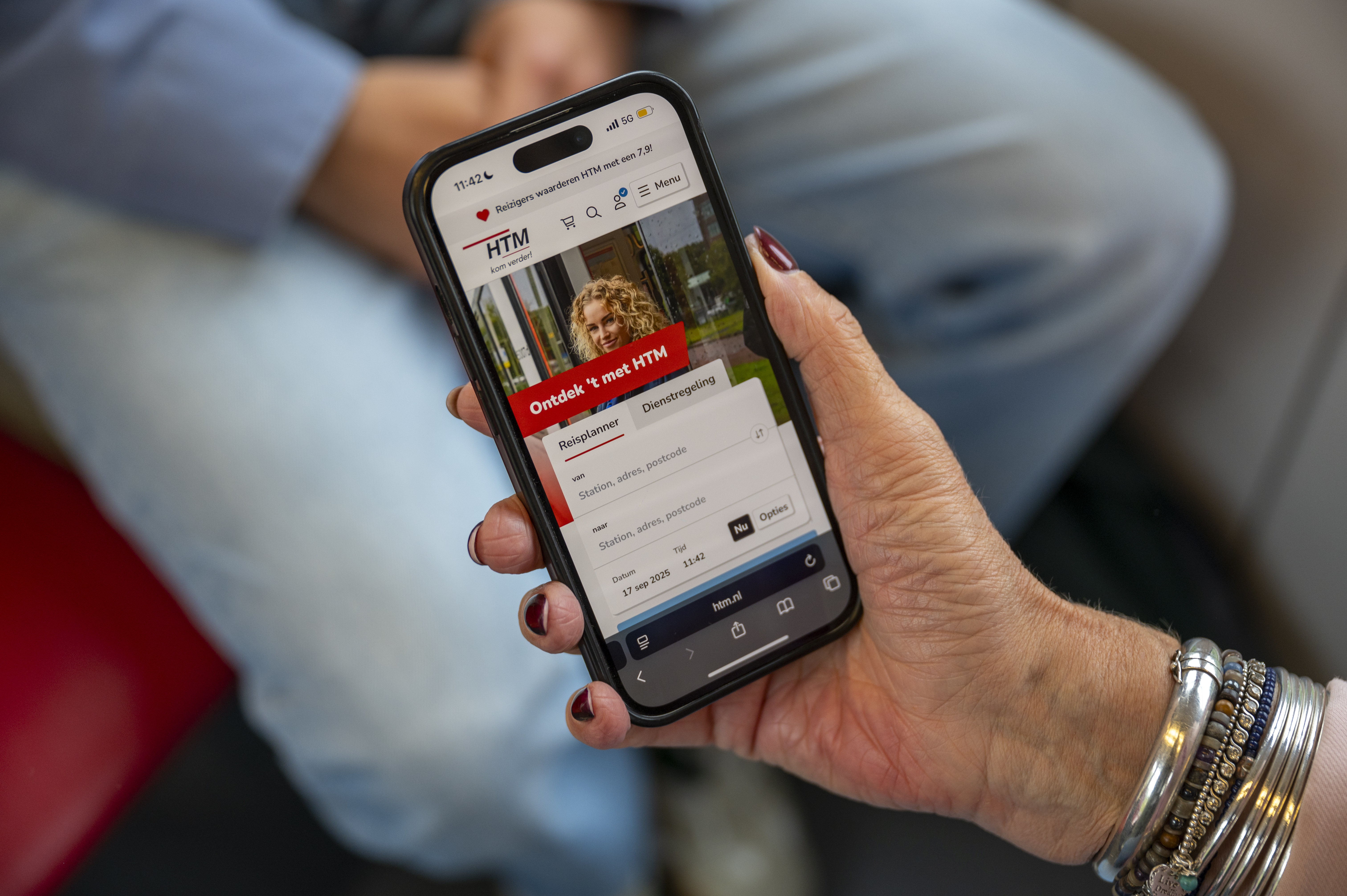 Reiziger Met Mobiel  in haar hand waarop je de htm website ziet
