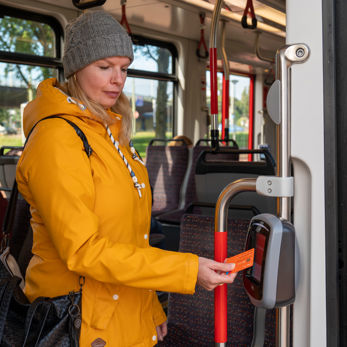 Vrouw checkt uit met pinpas Reiziger checkt uit met OV-pay in HTM tram